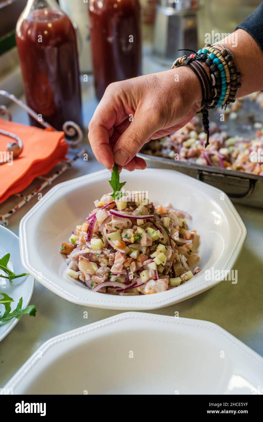 Crop anonymous male chef serving appetizing salad on plate placed on