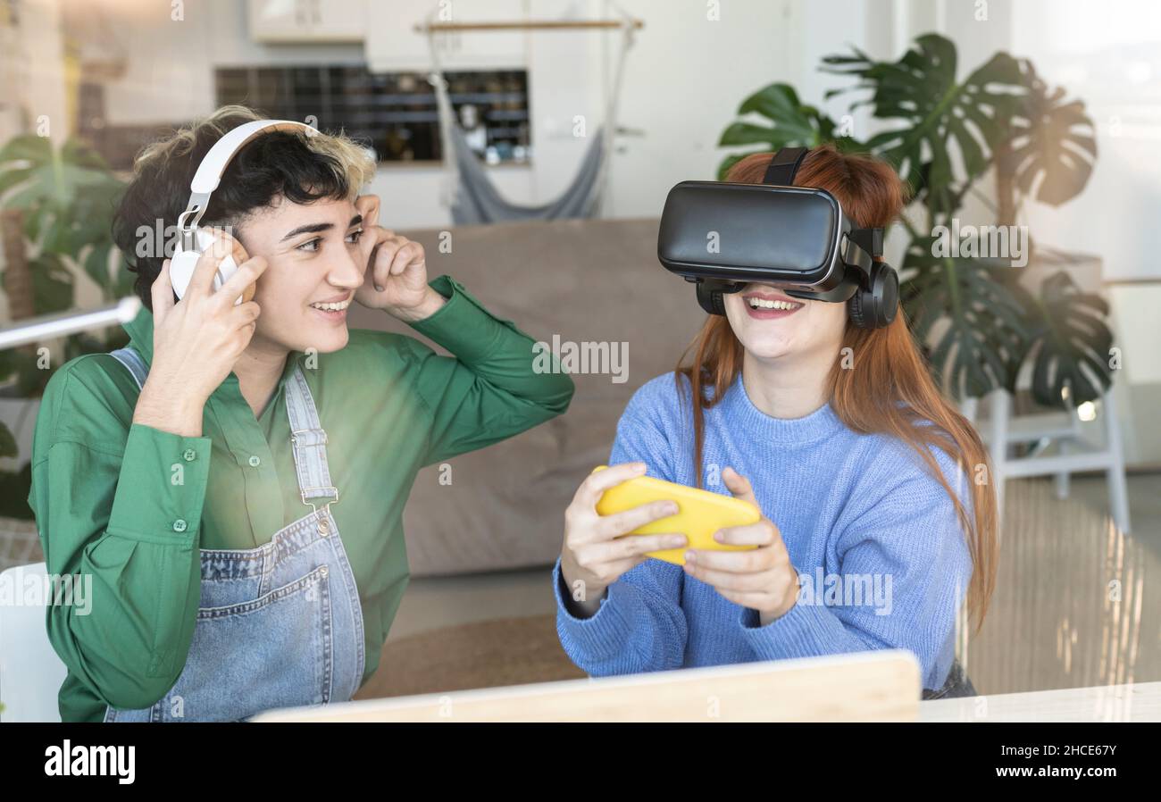 Cheerful female in modern VR headset with smartphone exploring virtual ...