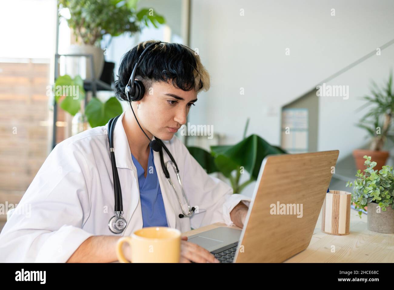 Focused female medical operator with headset in uniform and stethoscope