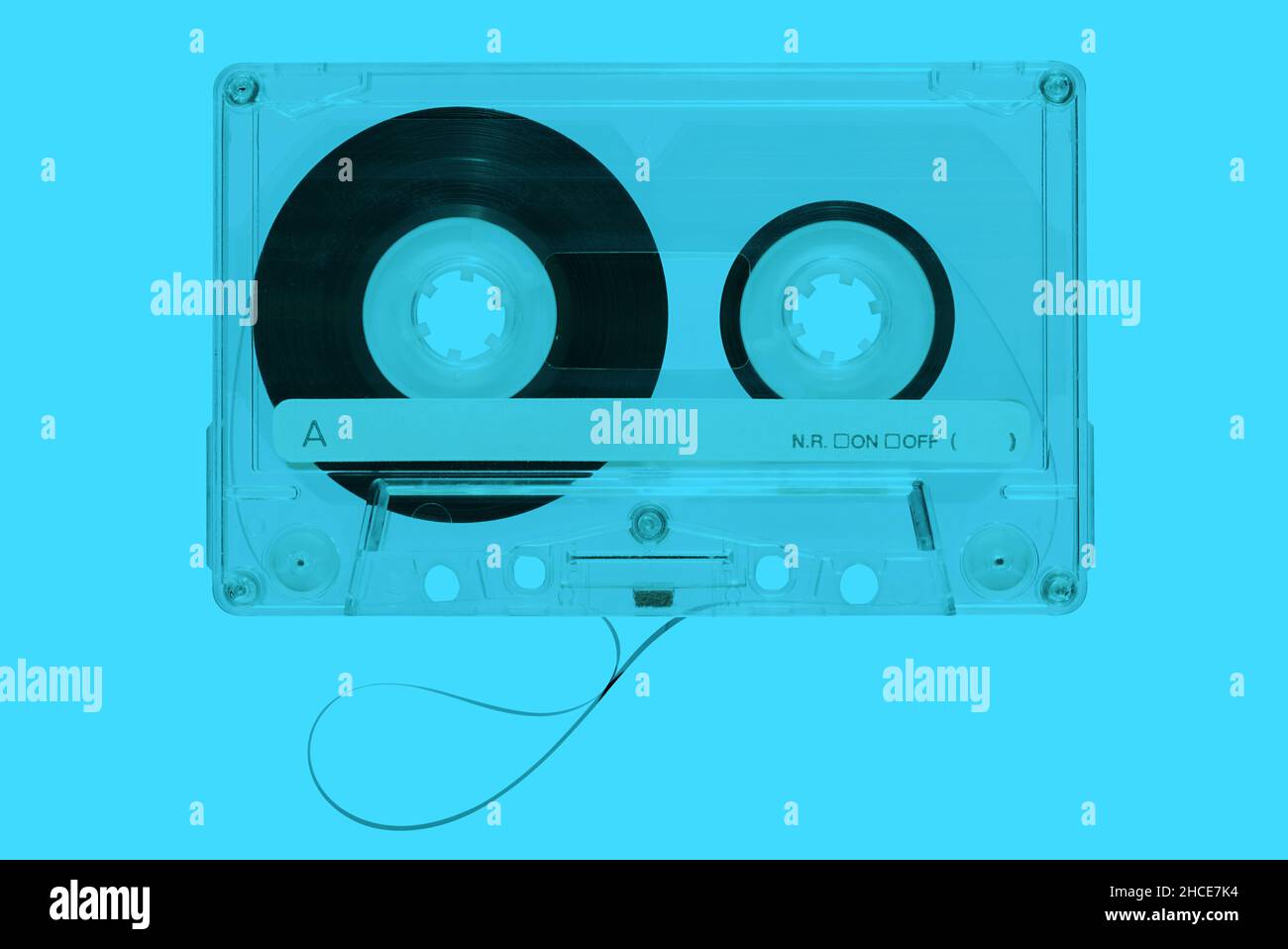 Top view of plastic vintage audio cassette with magnetic tape on bright blue background Stock Photo