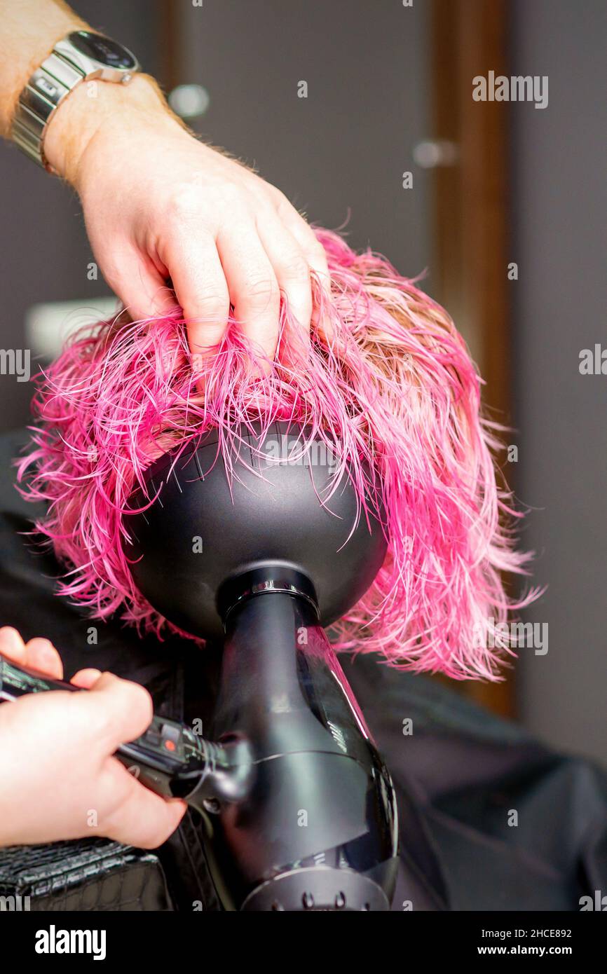 Hair Stylist making hairstyle using hair dryer blowing on wet custom