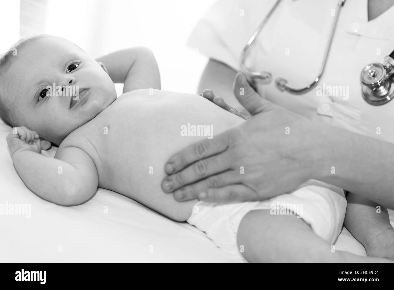 Doctor examining stomach female patient Black and White Stock Photos