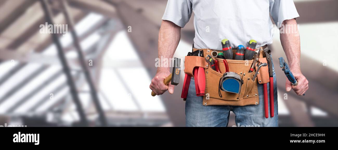Building worker with tool belt on a construction site background Stock