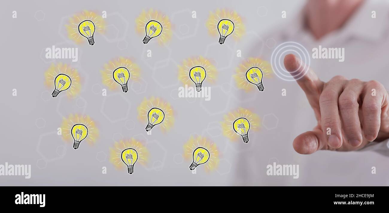 Man touching light bulbs on a touch screen with his finger Stock Photo