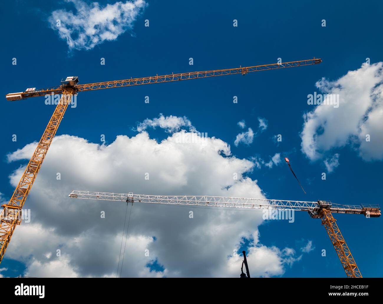 Low angle shot of tall cranes on a cloudy sky background Stock Photo ...