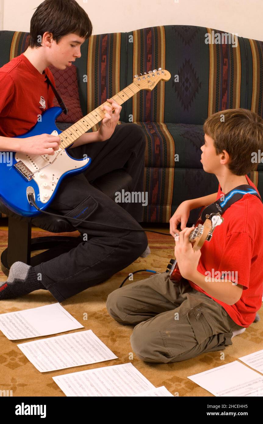 13 year old boy at home playing the electric guitar, playing with his