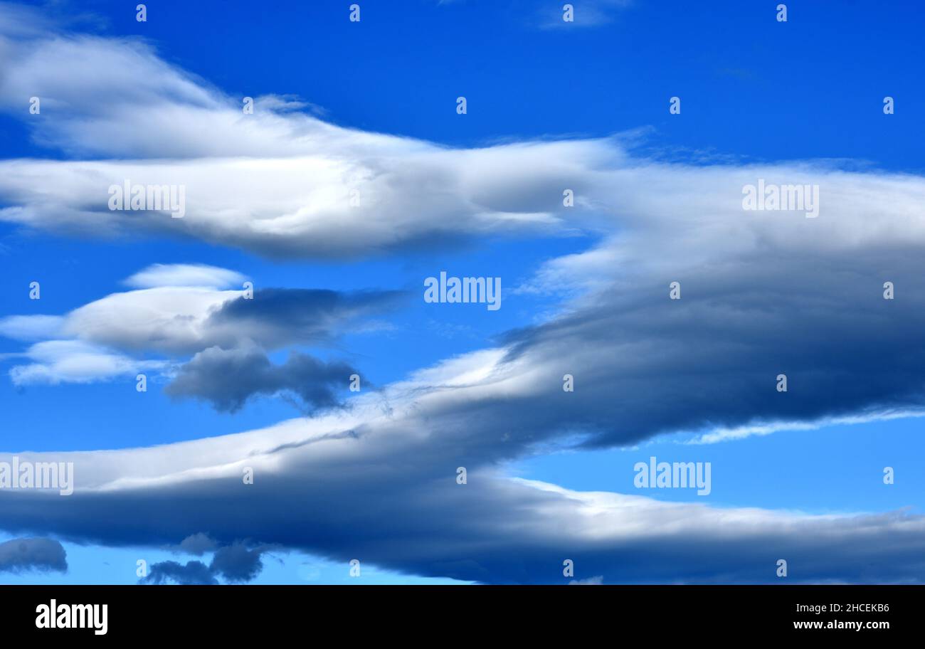 ltocumulus lenticularis clouds, more commonly known as lenticular clouds. These stationary,  lenticular or "UFO" clouds, appearing in smooth, layered Stock Photo