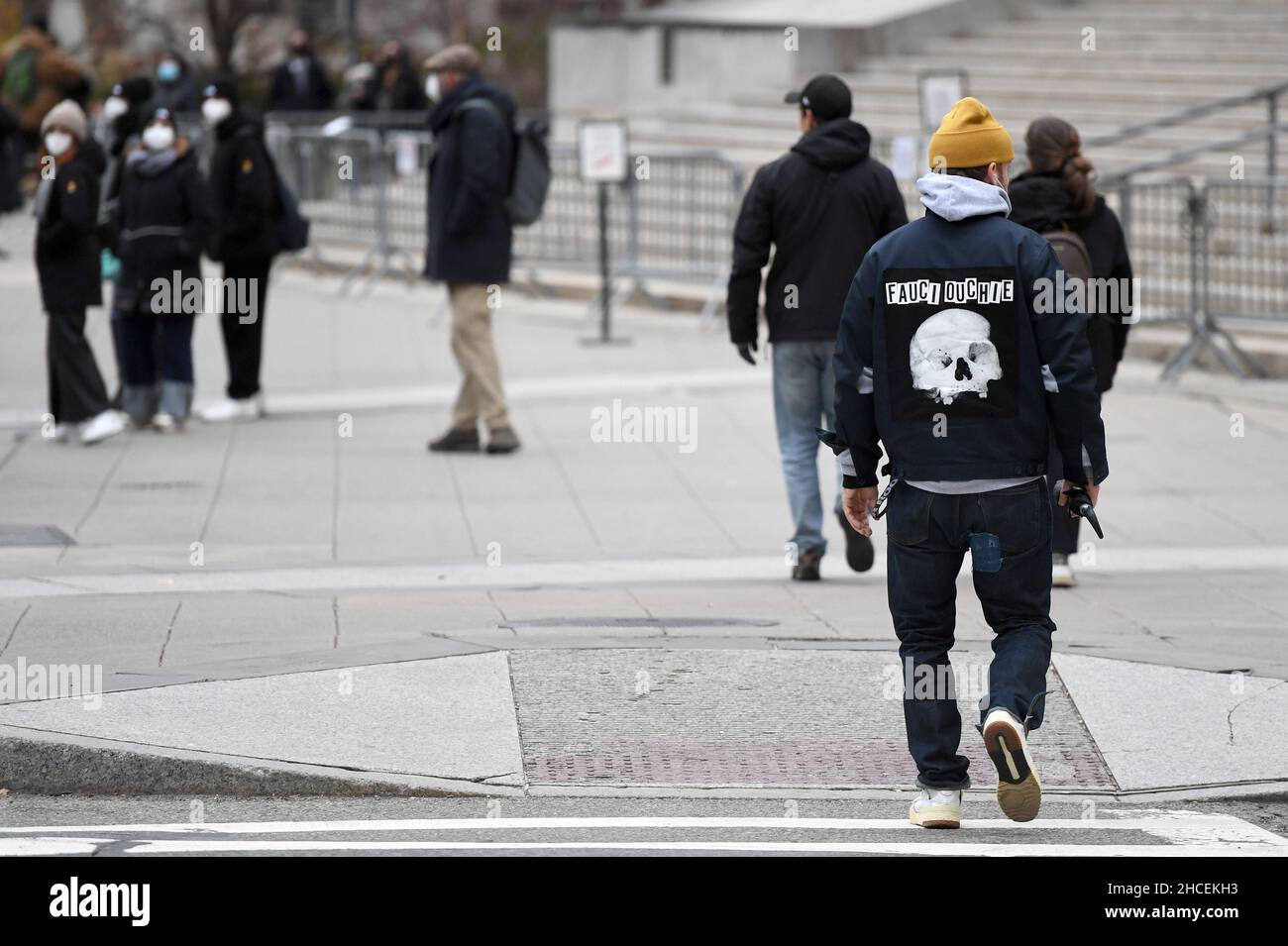 New York, USA. 27th Dec, 2021. A man (r) is seen wearing a jacket with the “Fauci Ouchie” wording and skull design on the back, in New York, NY, December 27, 2021. The term refers to Anthony Fauci, Chief Medical Advisor to the President of the United States and the rhyming of “Ouchie” referring to the COVID-19 injection which may be painful. (Photo by Anthony Behar/Sipa USA) Credit: Sipa USA/Alamy Live News Stock Photo