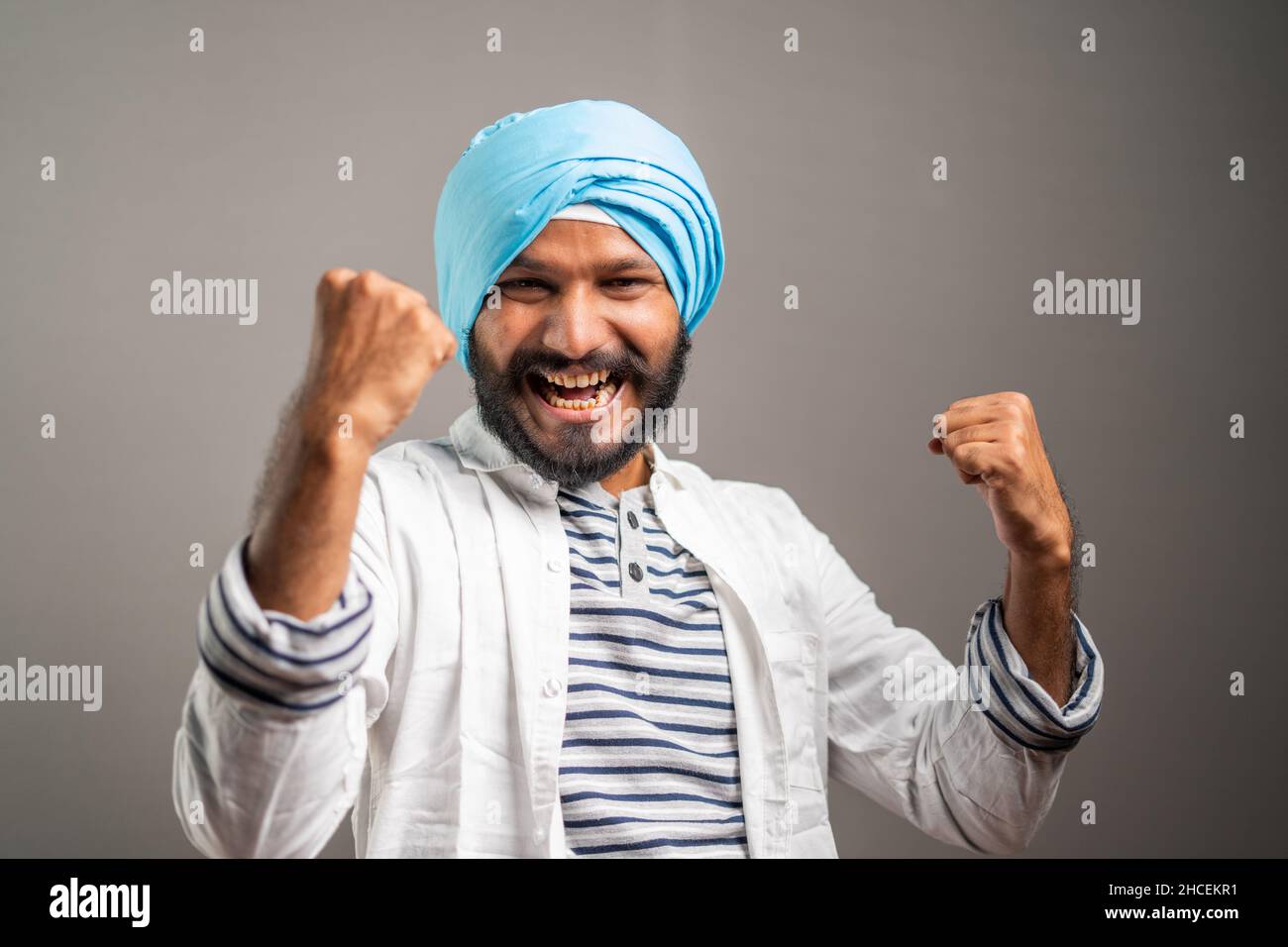 Excited sikh man celebrating succes by shouting and showing hand gesture by looking at camera - concept of job promotion,good news and won lottery. Stock Photo