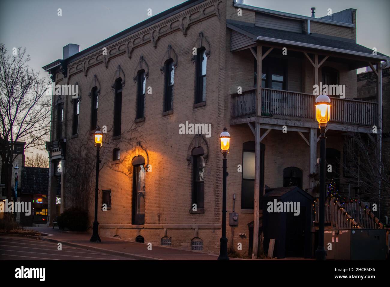 Facade of the brown building in the evening illuminated by street lamps. Stock Photo