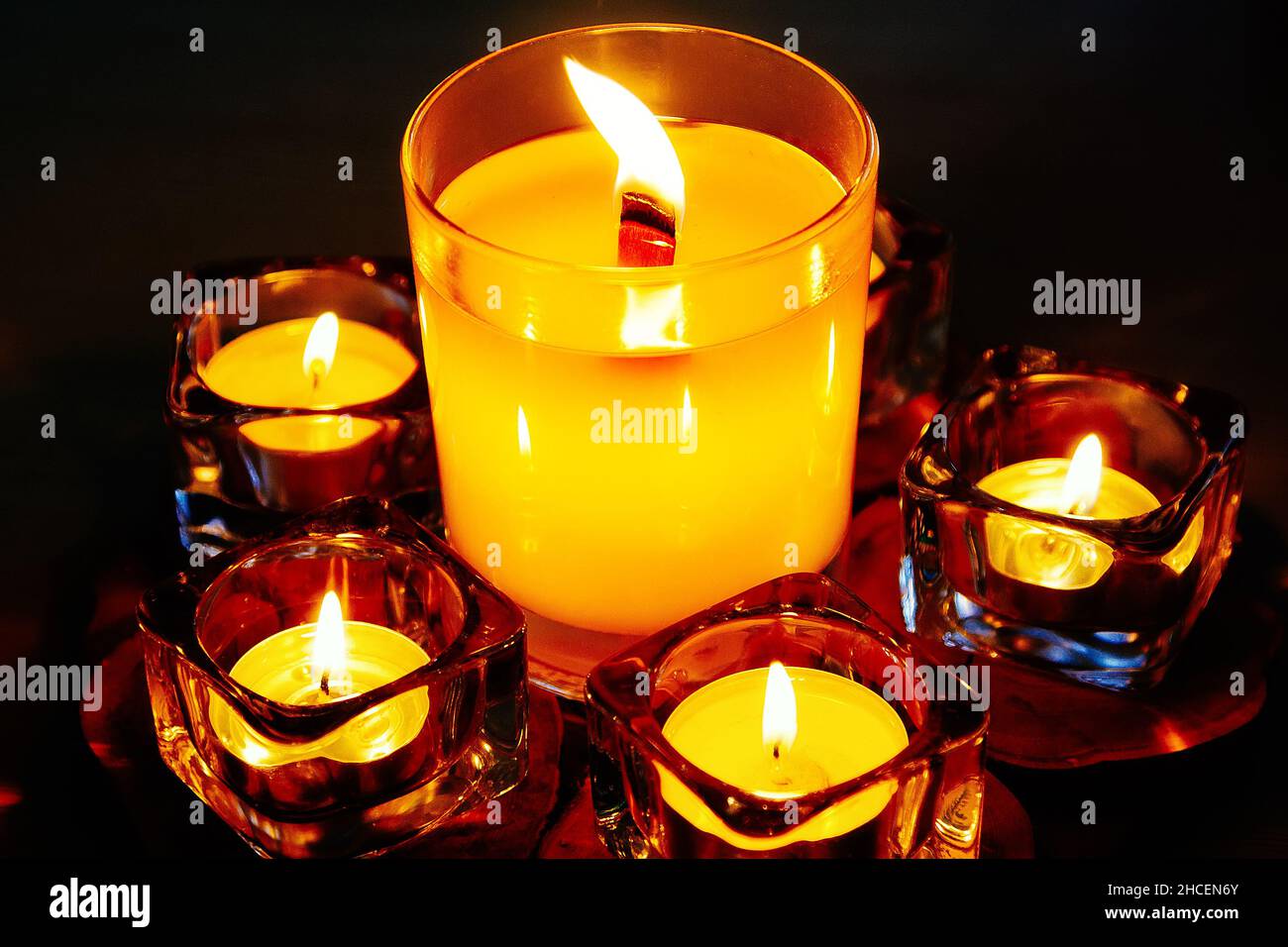 Set of beautiful scented candles in crystal candlesticks burn in dark