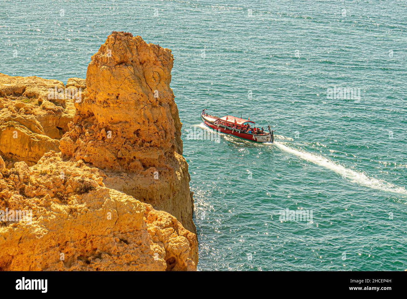 Tourist boat sailing past Algar Seco Carvoeiro Coastline Portugal Stock Photo