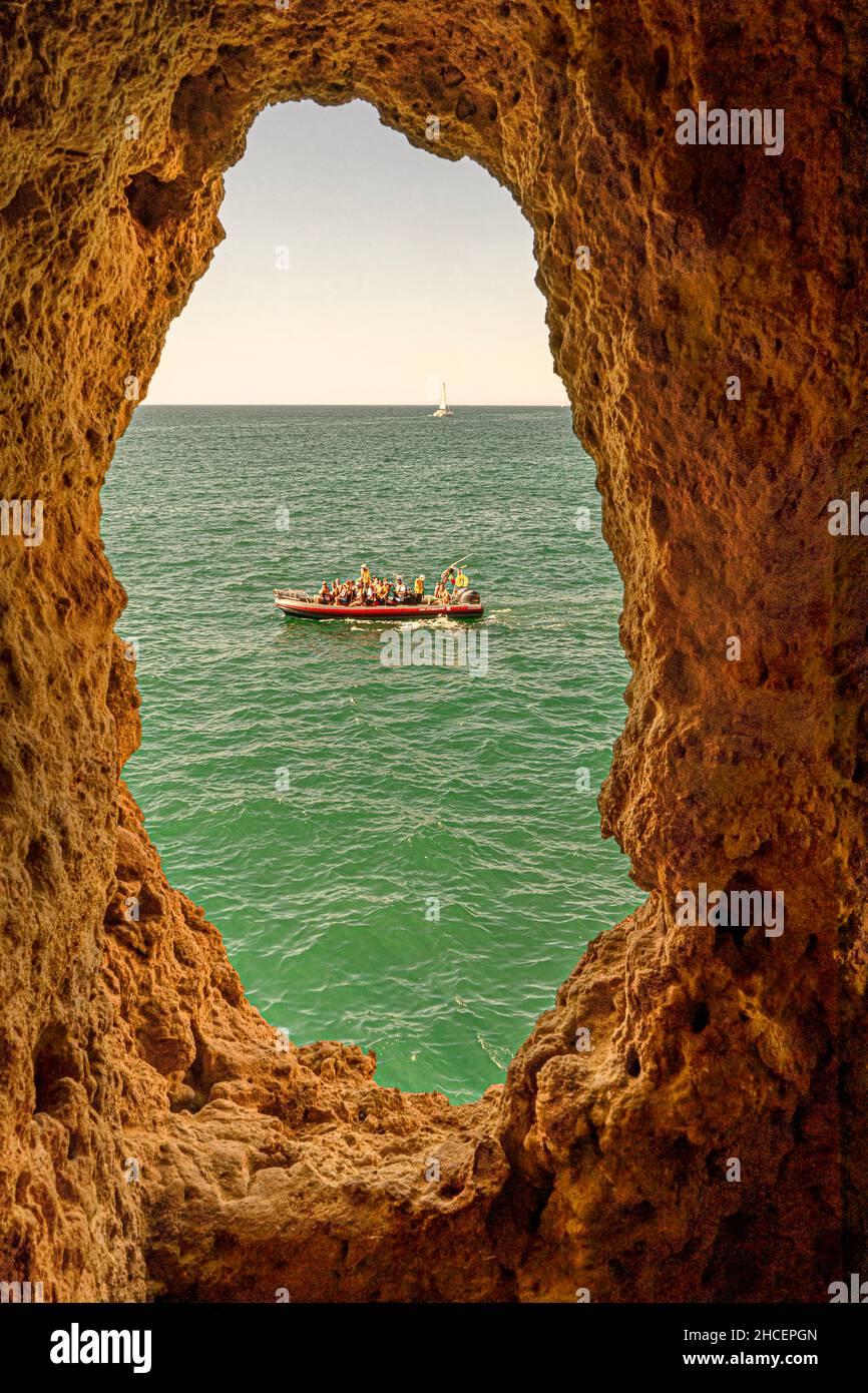 Tourist boat through an Algar Seco cave window Carvoeiro Portugal Stock Photo