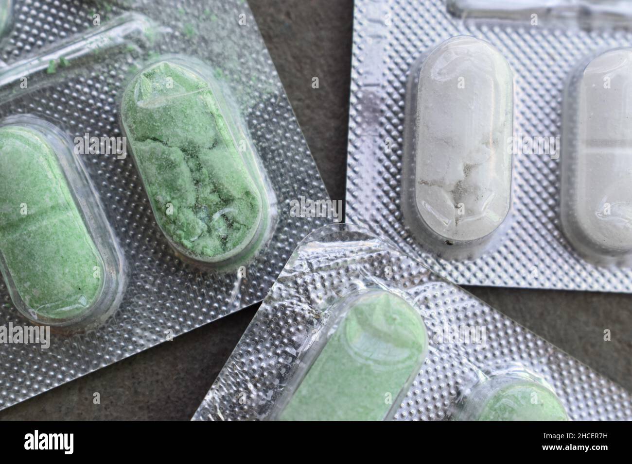 Crushed and damaged tablets in closeup view. Concept of expired drugs