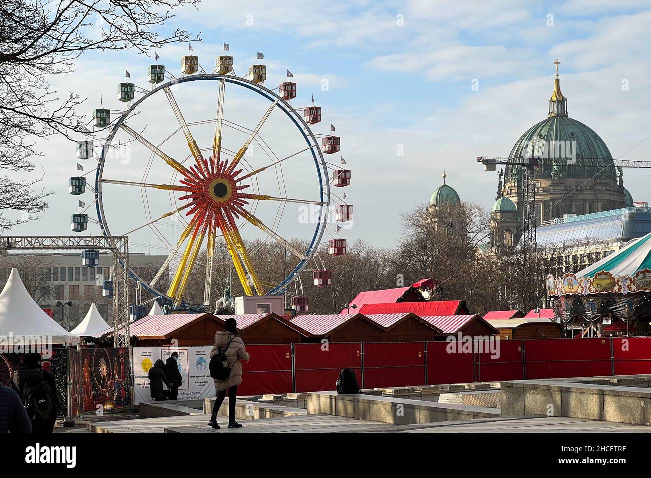Ferris wheel spinning on a Christmas Market at Alexanderplatz in Berlin on a sunny winter day. Stock Photo