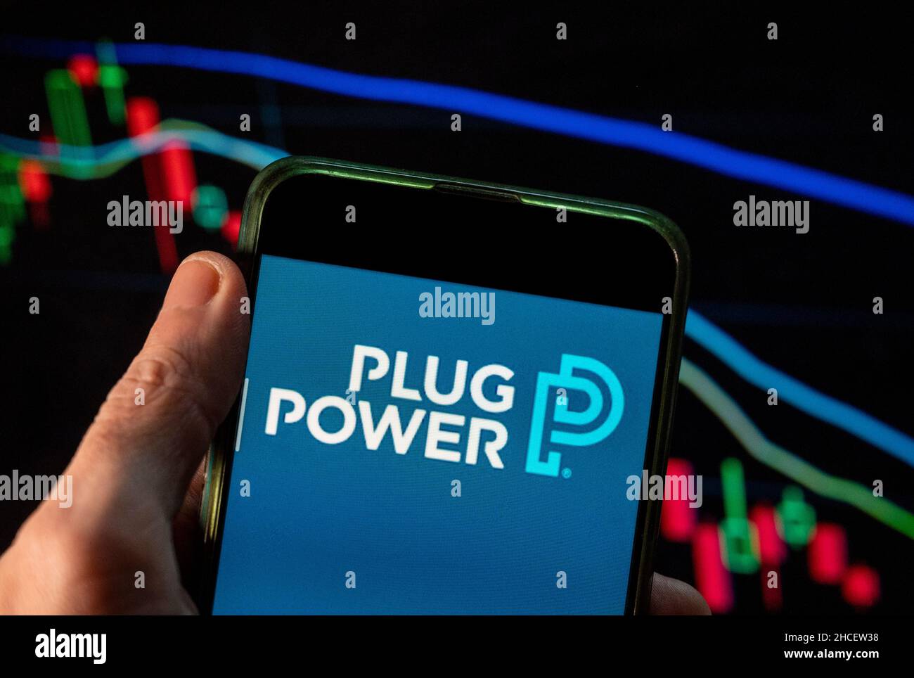 In this photo illustration the American company engaged in the development of hydrogen fuel cell systems that replace conventional batteries in equipment, Power Plug, logo seen displayed on a smartphone with an economic stock exchange index graph in the background. Stock Photo