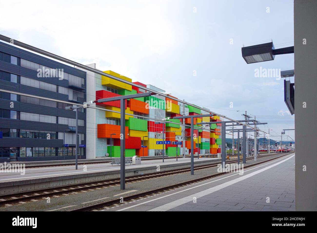 On a platform Salzburg main station. Opposite a colorful Apartment house with red, yellow, orange and green balconies. Stock Photo