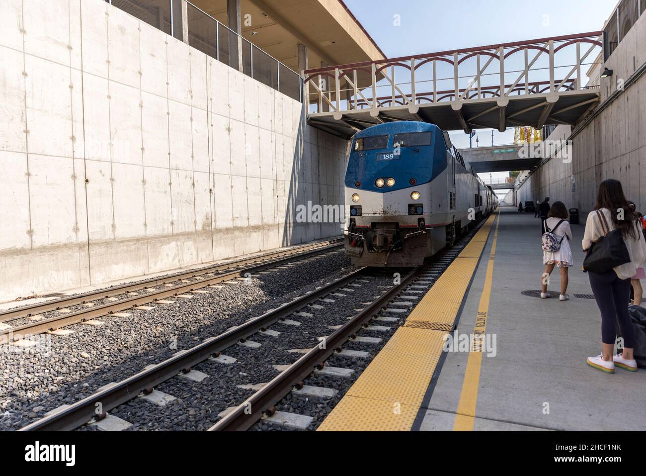 People line up on a platform below ground to board a train Stock Photo ...