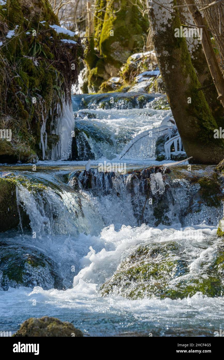 ice-cold stream with cascades and icicles in winter Stock Photo