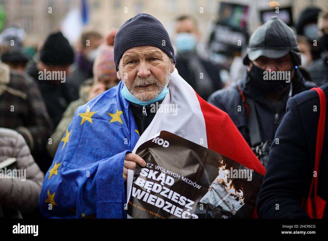 A senior protester holds a banner saying 'From where you would get the news?', advocating media freedom.  Poland's parliament recently passed a contro Stock Photo