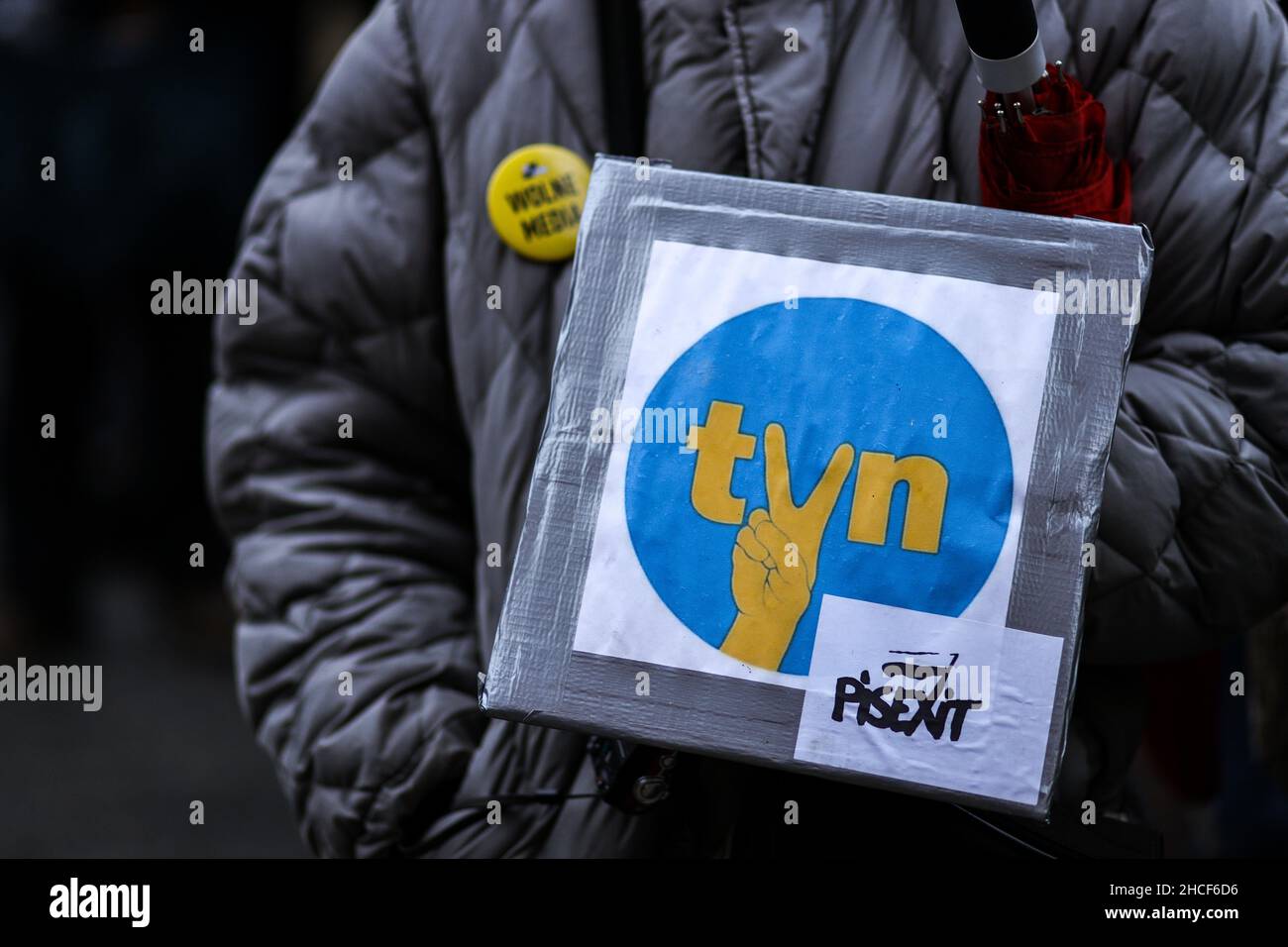 A banner with a logo of TVN broadcasting company and a 'victory' gesture is seen on a protester's coat.  Poland's parliament recently passed a controv Stock Photo