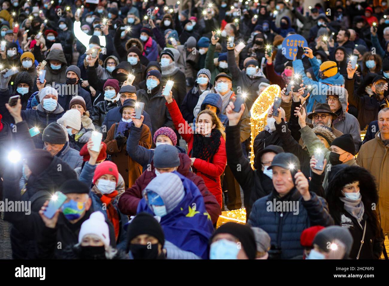 Protesters wearing protective face masks and holding flash lights and banners advocating for press freedom during a protest against law restricting me Stock Photo