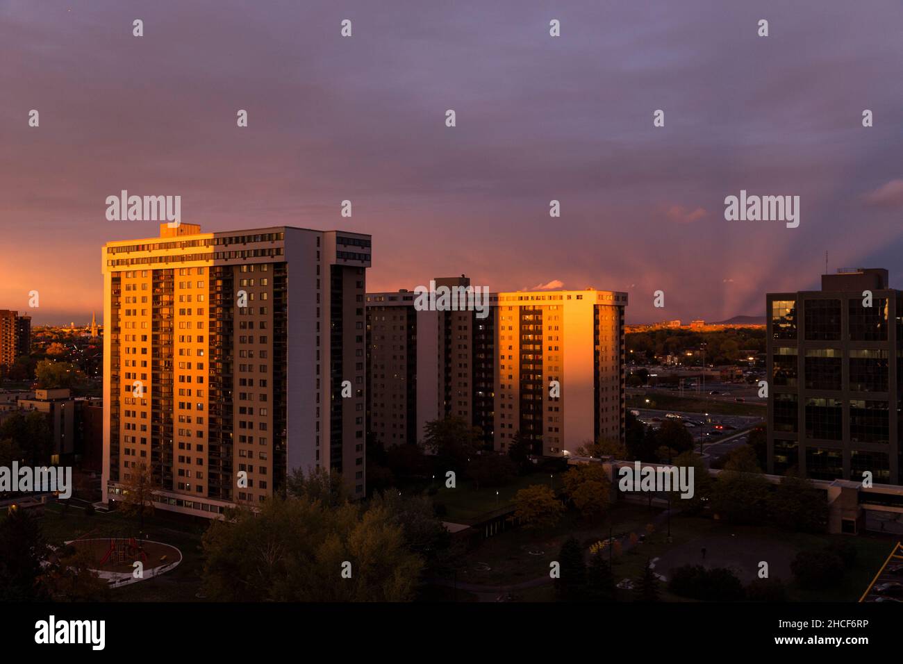 Sunset colours the clouds over buildings in the Longueuil metro area