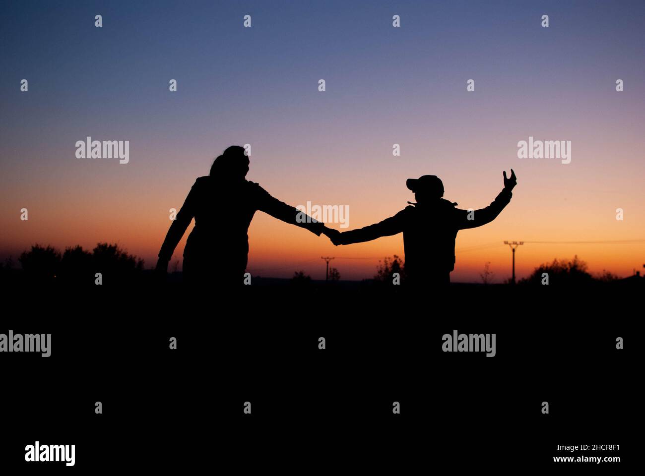 Siluet of the family, mom and son outside in the dark during the sunset Stock Photo