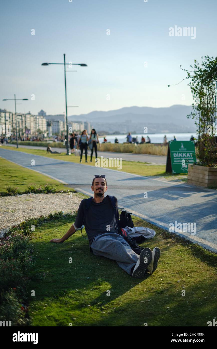 Happy looking man lying on the grass while posing for a picture Stock Photo