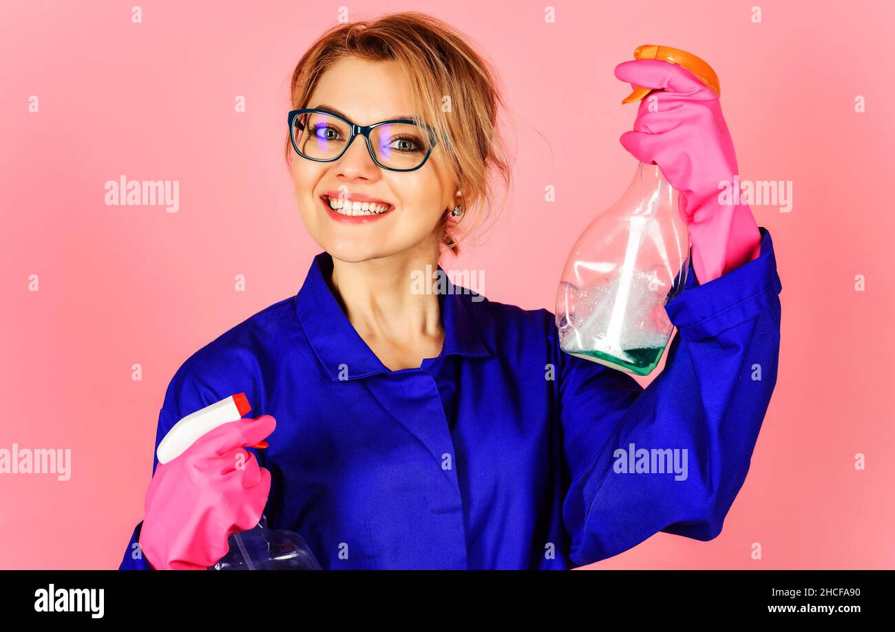Happy woman with cleaning spray. Female housemaid, cleaning worker in protective gloves and uniform. Stock Photo