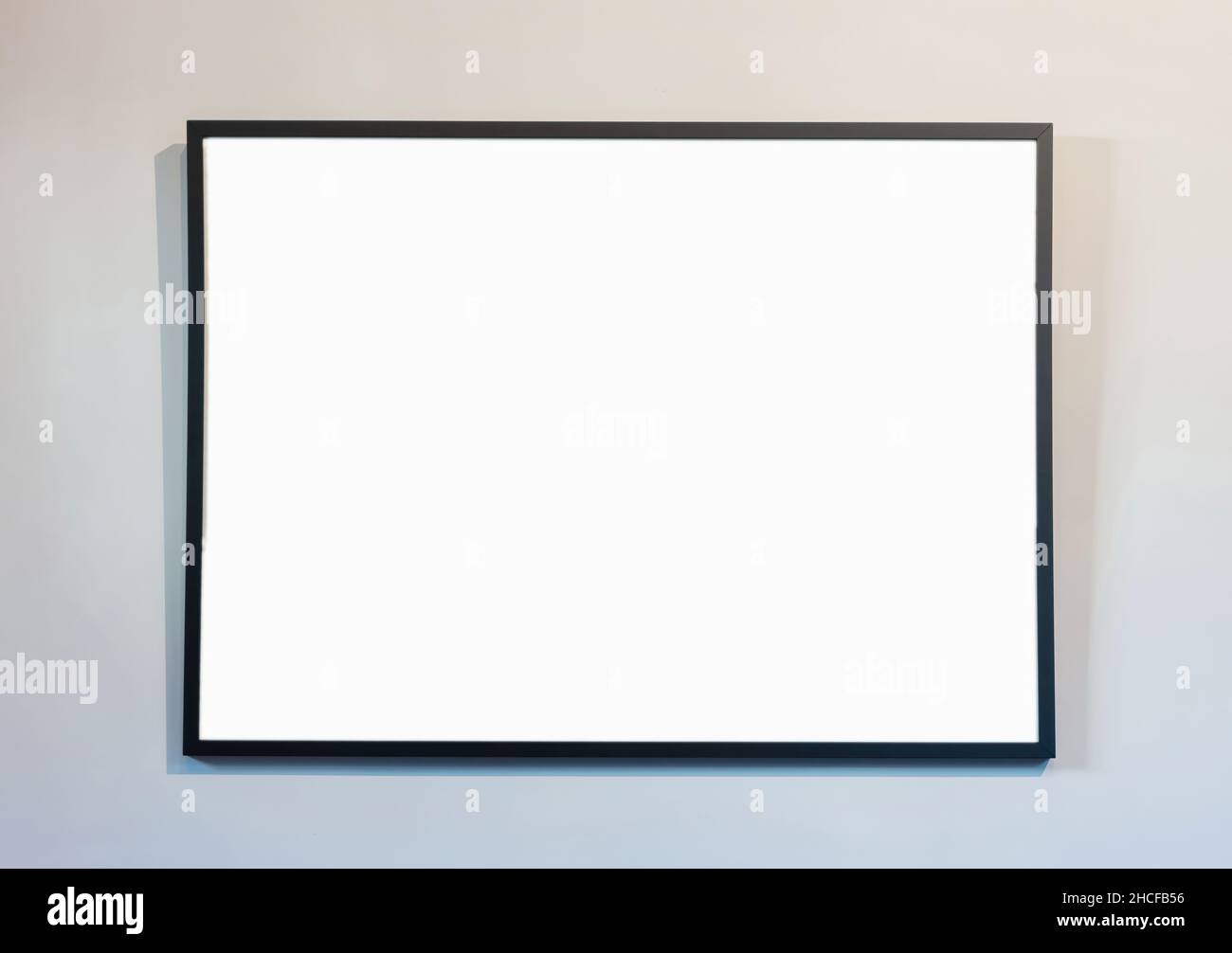 Empty frame on white wall background, copy space. Poster mockup. Black, modern, minimal border for text, ad, product presentation Stock Photo