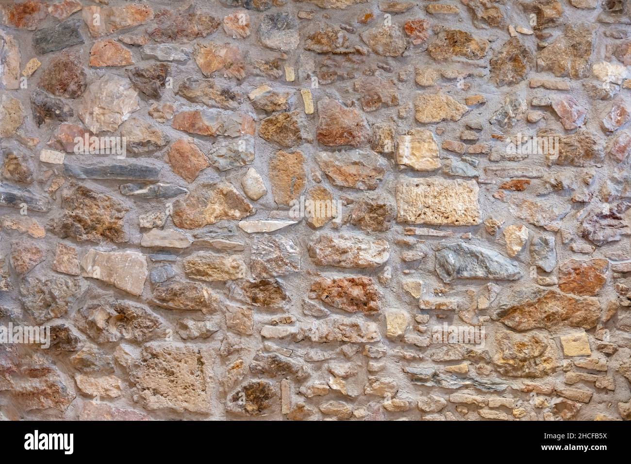 Stone wall texture background. Old stonewall traditional pattern building facade, natural material for cladding and flooring Stock Photo