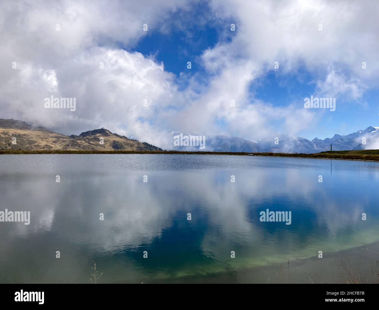Blue Mountain Lake with Clouds above Bettmeralp, Aletsch Arena, Switzerland Stock Photo