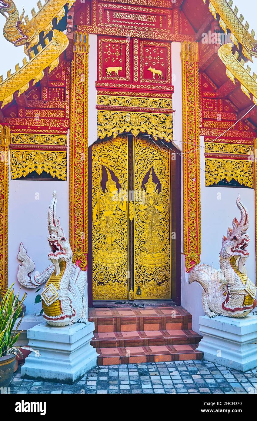 The facade of the Ubosot of Wat Muen Ngoen Kong temple with stunning door, decorated with gilt patterns and Devata figures and the sculptures of Naga Stock Photo