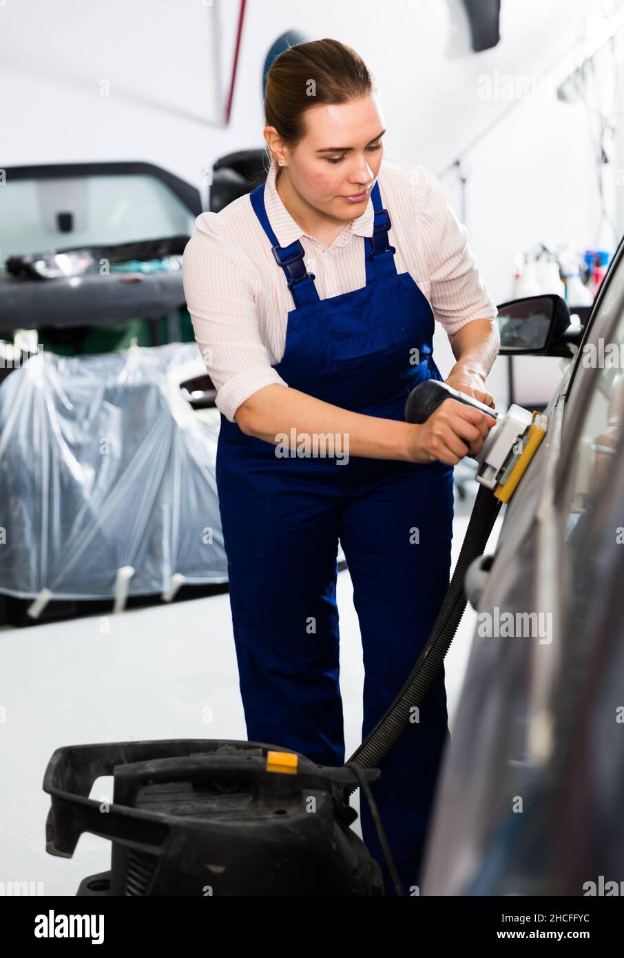 Woman mechanic sanding automobile body Stock Photo Alamy