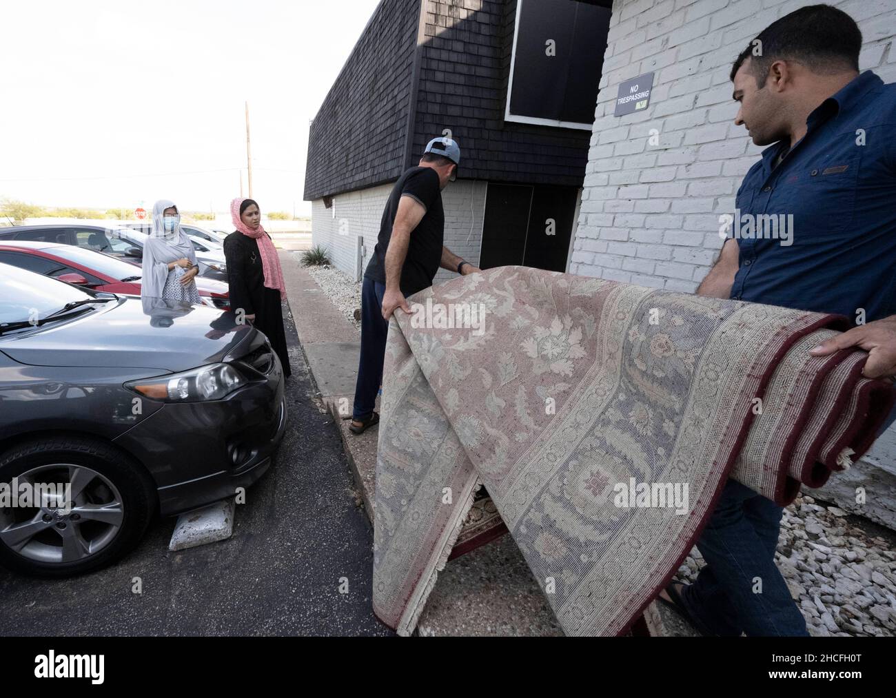 Austin, TX, USA. 2nd Oct, 2021. Two Afghan men carry a donated rug to