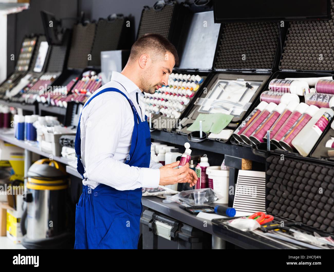 Professional car painter preparing paints for paintwork in modern auto repair shop Stock Photo