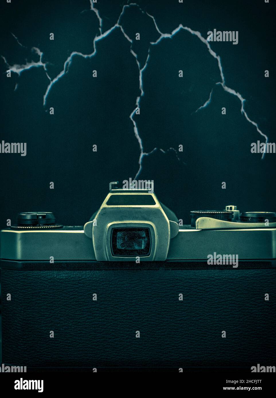 Composite image featuring rear view of analogue film camera with lightning effect coming from hotshoe of camera Stock Photo
