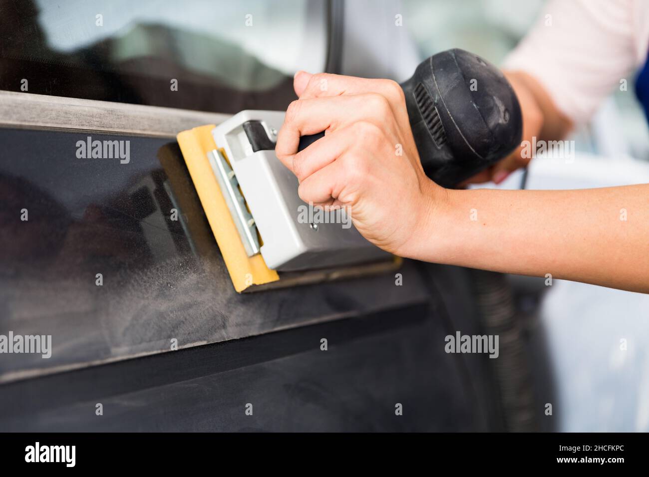Sanding tool in female hands grinding car body Stock Photo Alamy