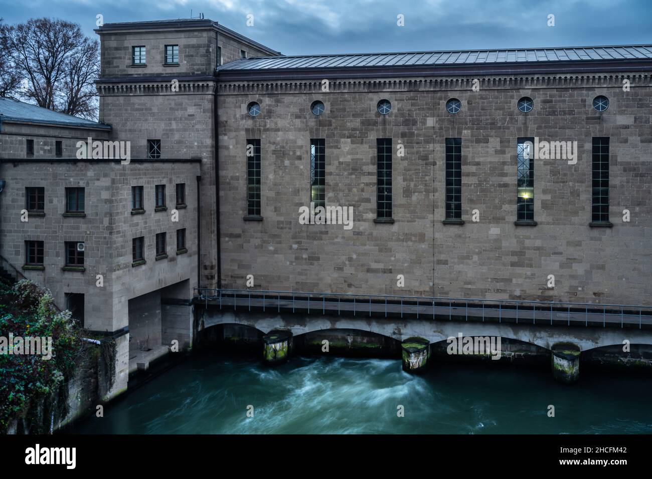 Raffelberg hydroelectric power station in Mülheim an der Ruhr, Speldorf, Germany. One  of the water gates is open and the green water is floating. Stock Photo