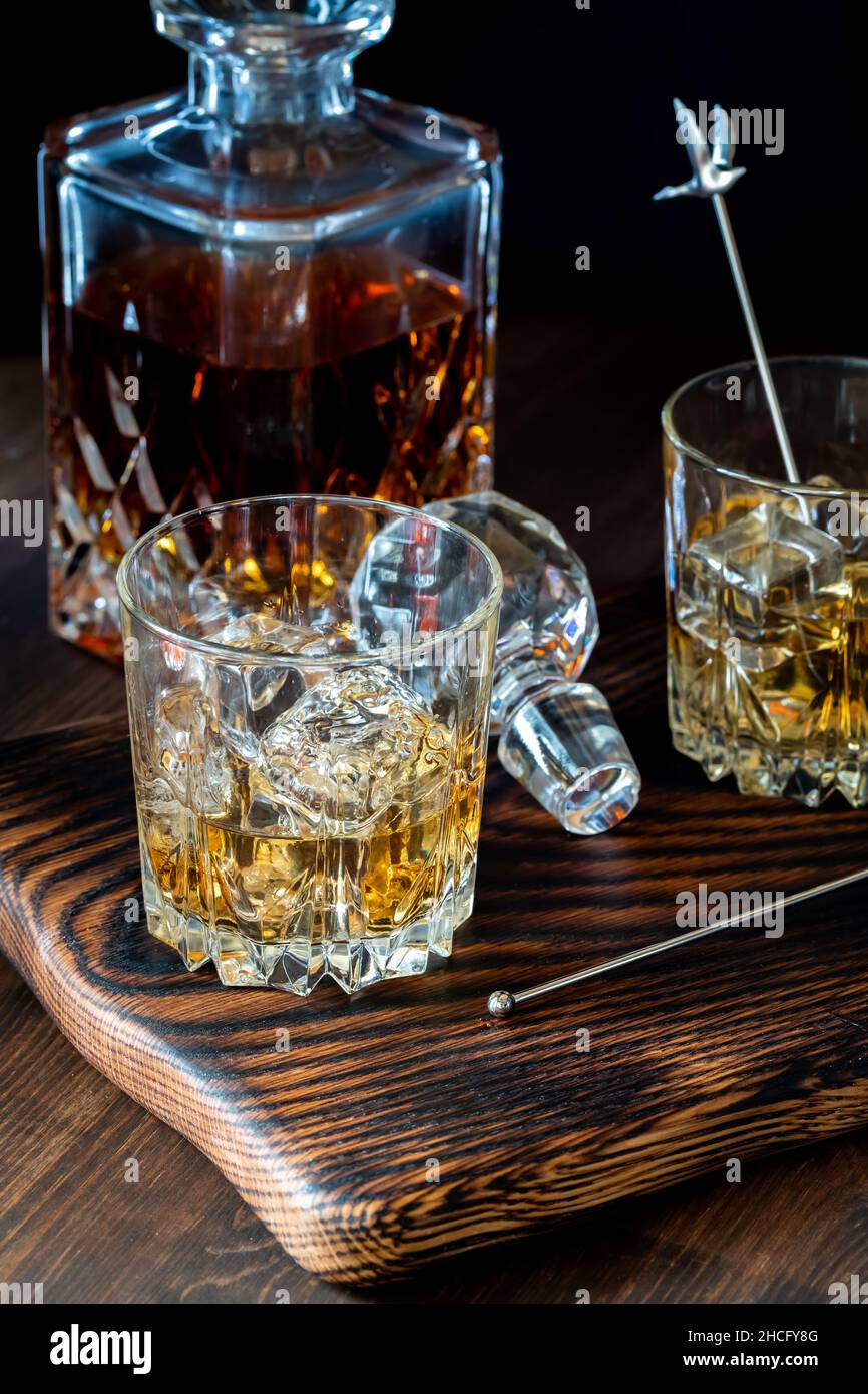 https://c8.alamy.com/comp/2HCFY8G/glasses-of-whiskey-with-ice-and-a-full-decanter-of-whiskey-in-behind-2HCFY8G.jpg