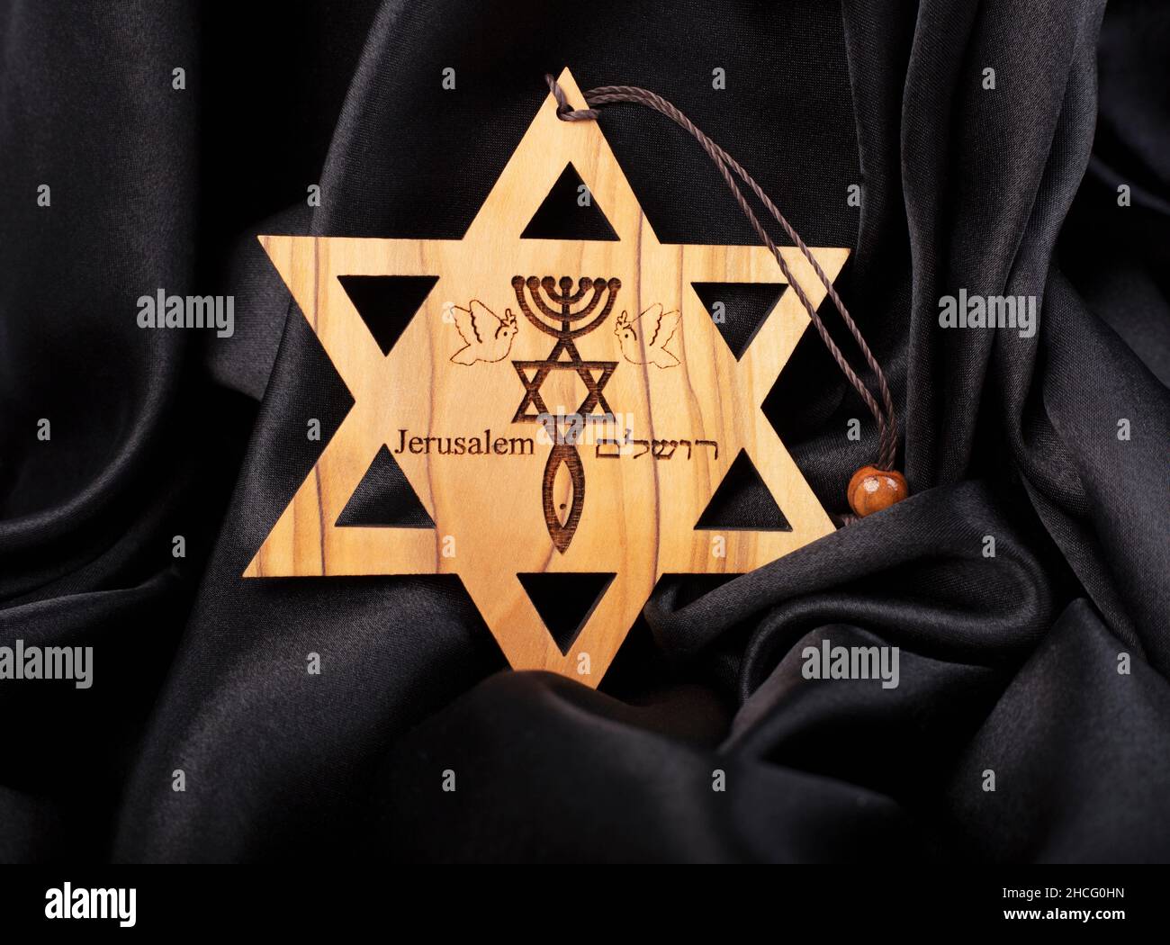 Wooden star of david on black silk background Stock Photo