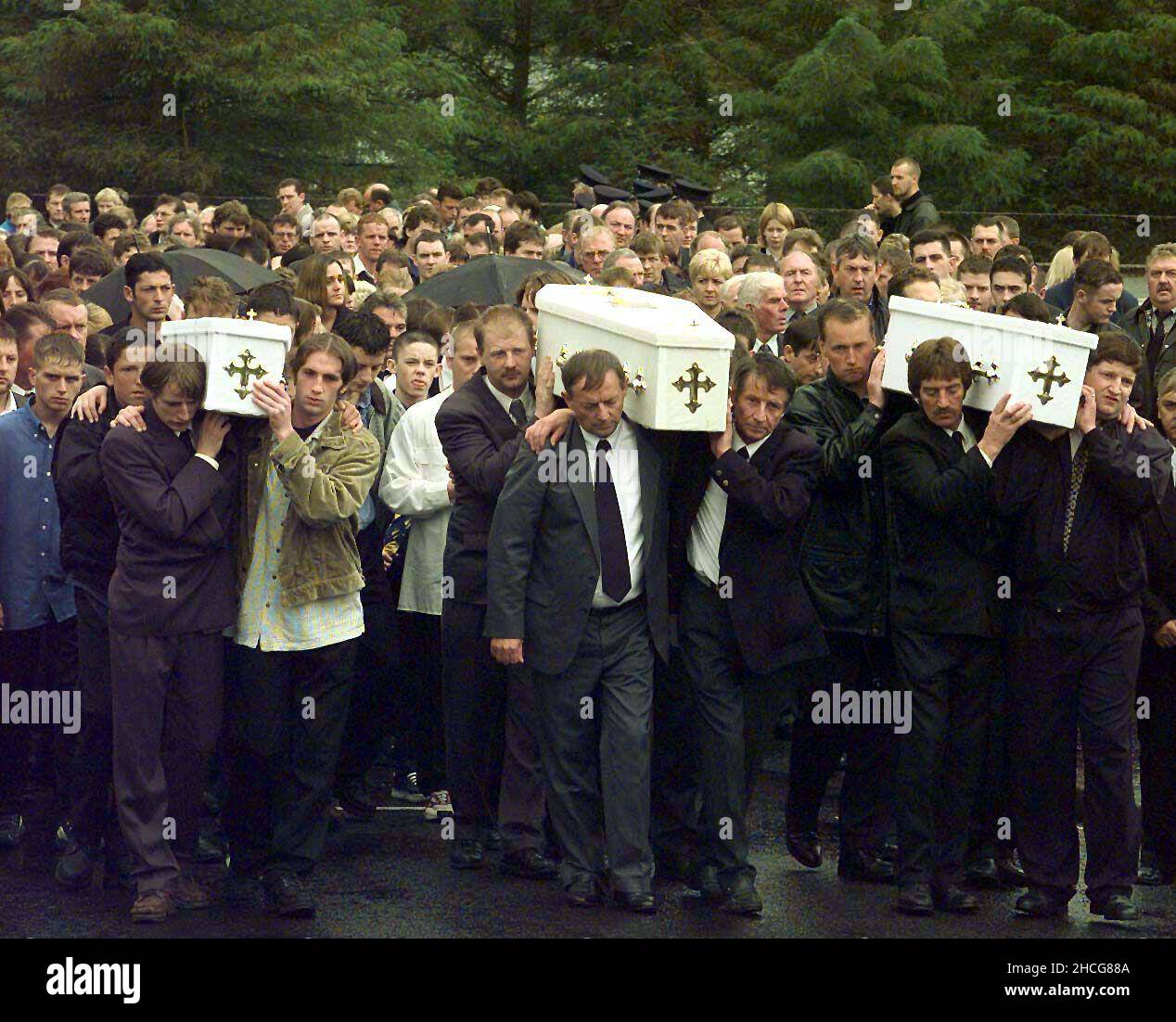 File photo dated 14/07/98 of the three coffins of brothers Richard, Mark, Jason Quinn, who were killed in a sectarian arson attack, being carried by family and mourners to Rasharkin Church for burial after leaving funeral mass at the Church of Our Lady and St Patricks, Ballymoney. Prime Minister Tony Blair told the head of the Orange Order to call for an immediate end to the Drumcree parading dispute hours after three young brothers were killed in a loyalist firebomb attack, according to newly released documents from the National Archives. Issue date: Wednesday December 29, 2021. Stock Photo
