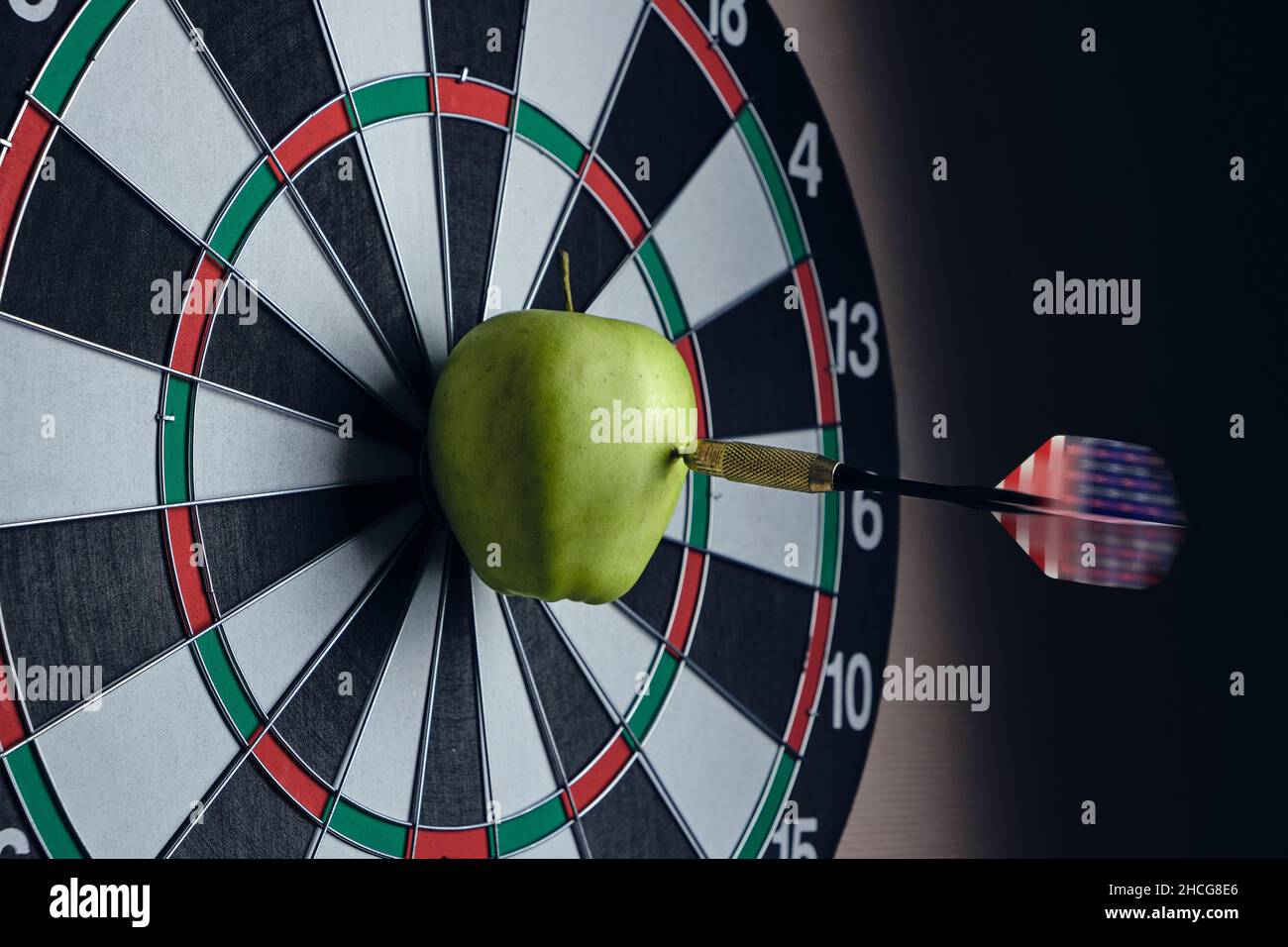 Game of darts, flying dart and hitting right on bullseye Stock Photo