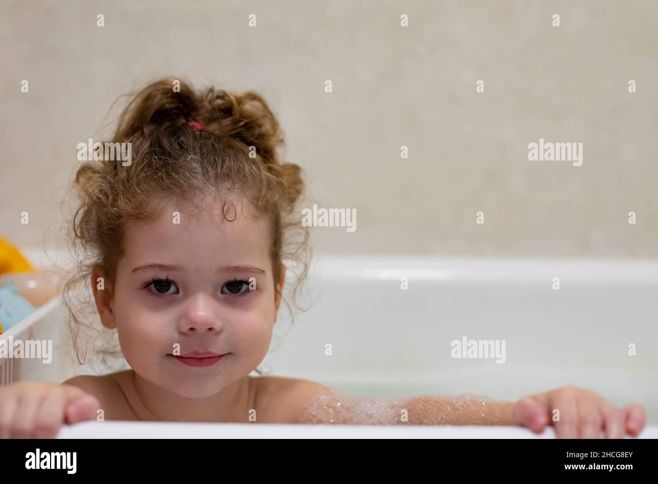 Little caucasian girl taking a bath, caring for and bathing a child ...