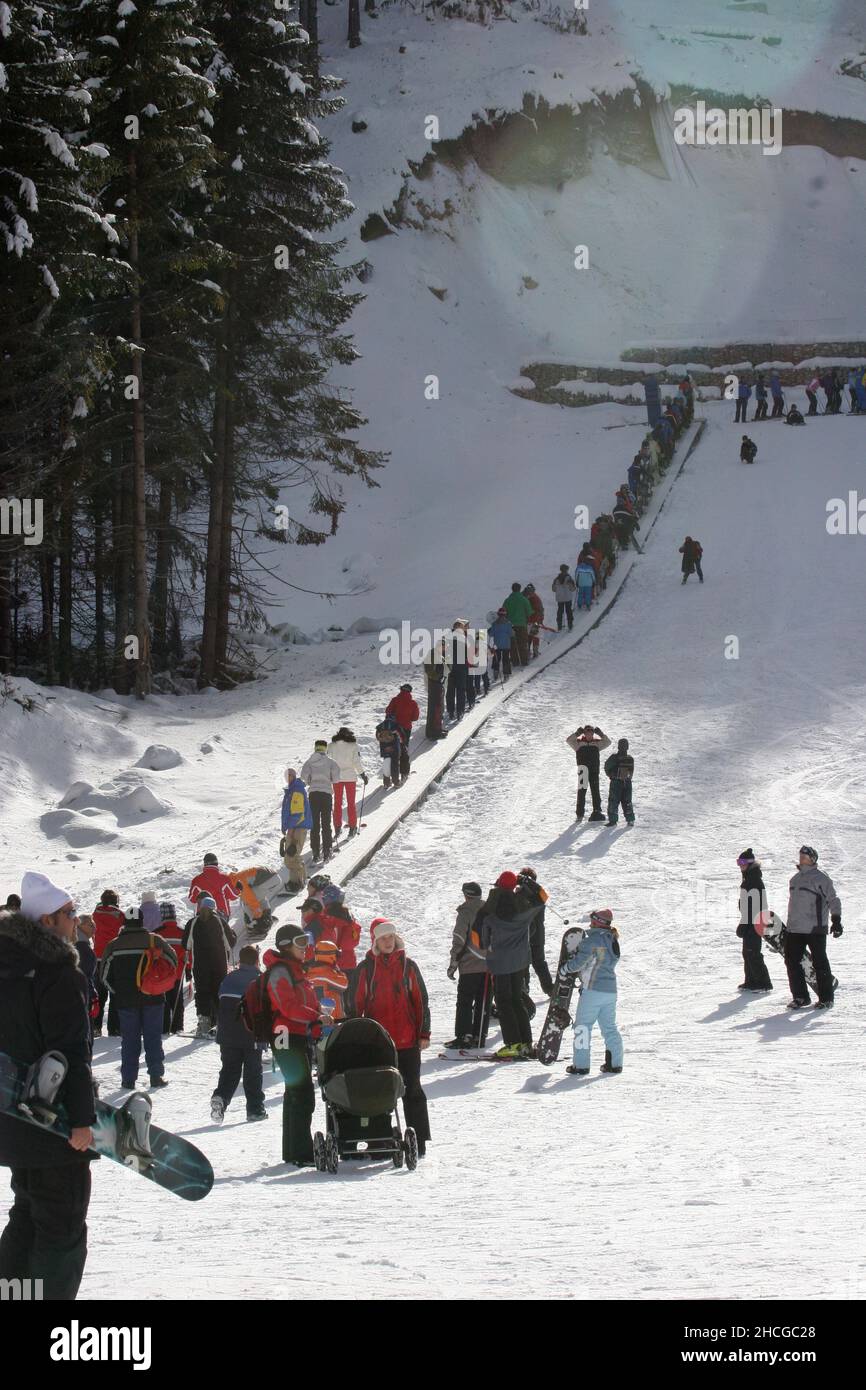 People are skiing near gondola lift in mountain Pirin, in Bansko, Bulgaria on Jan 26, 2008. Stock Photo