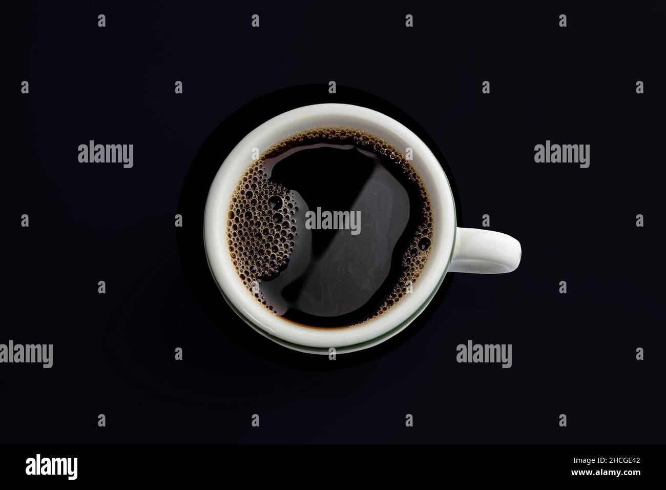 Closeup shot of a white mug of black coffee isolated on a black background Stock Photo