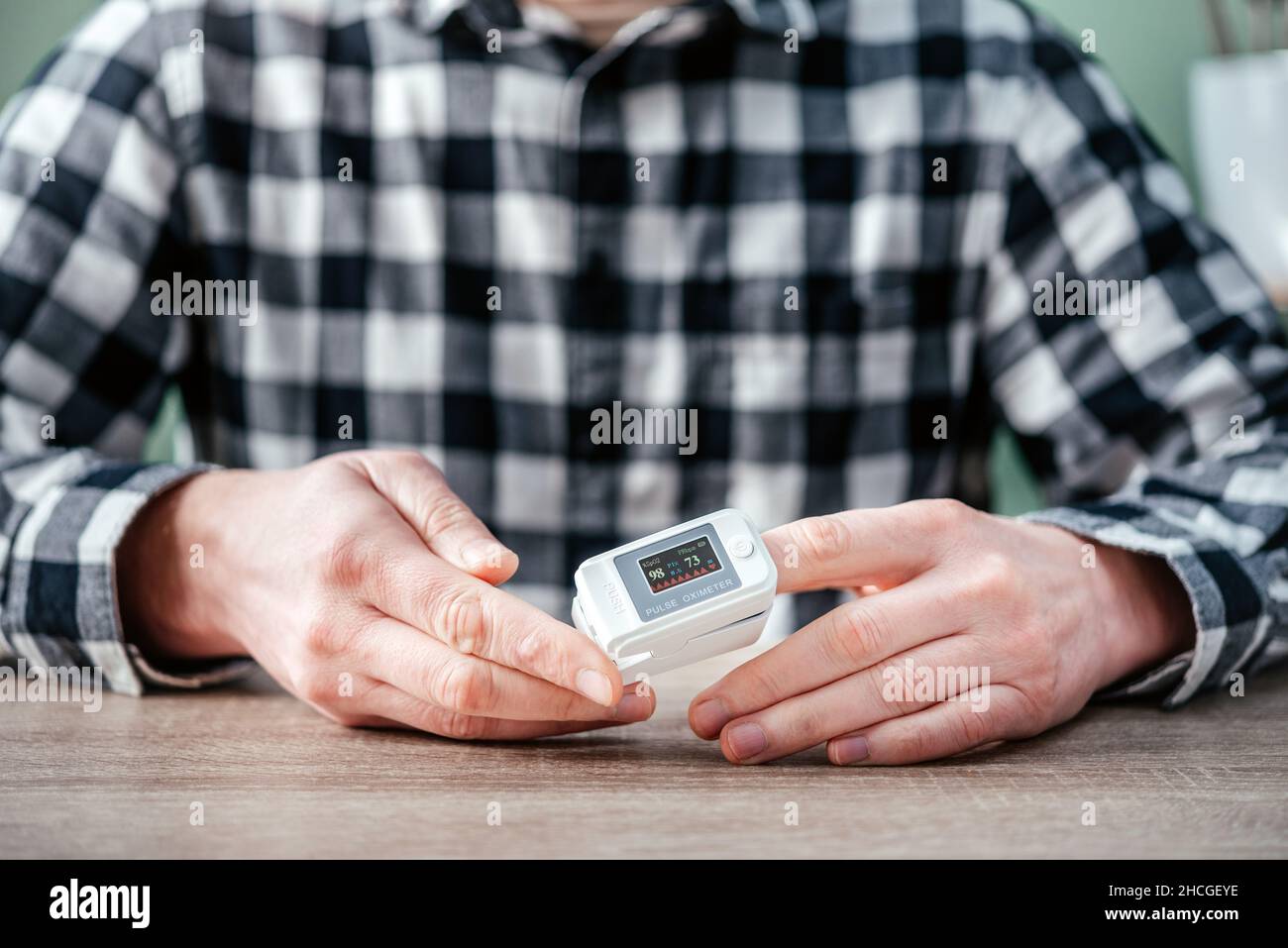 A man checking oxygen level at home with home oximeter, patient
