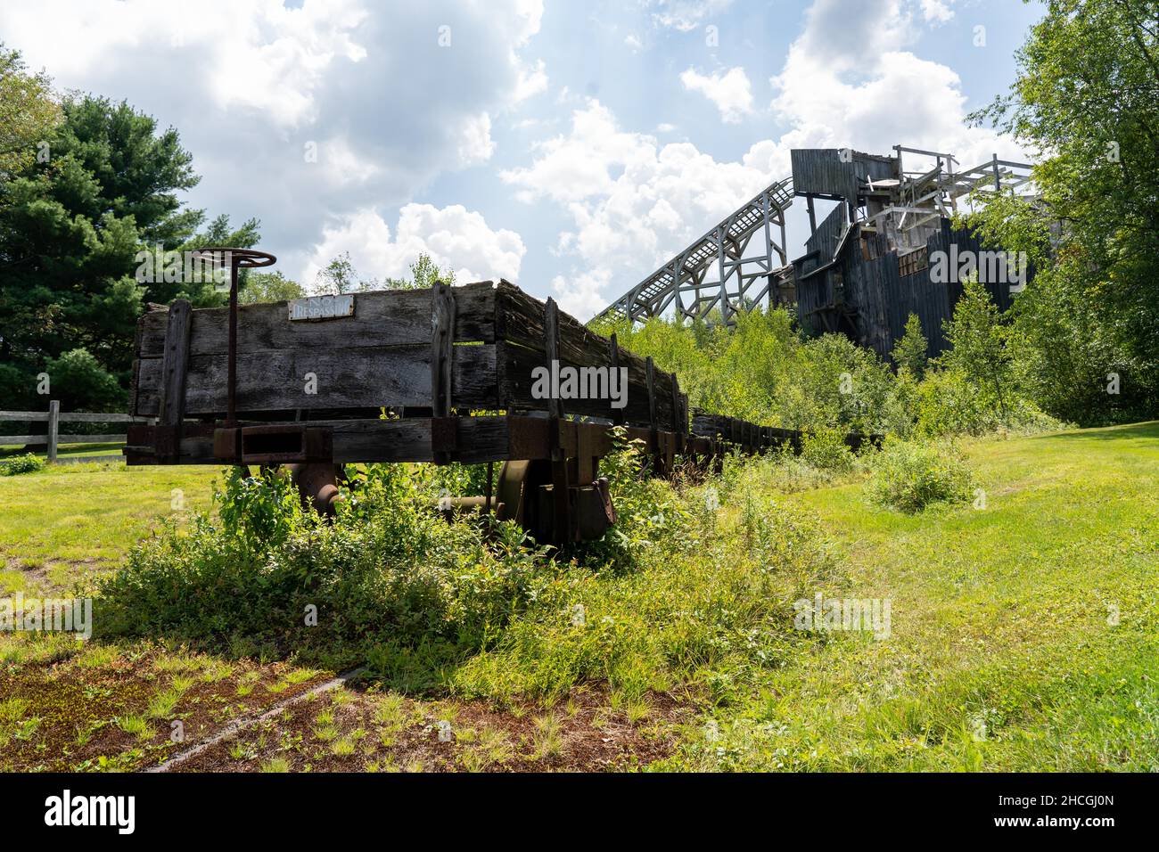 A historic coal breaker with a dilapidated rail car in the foreground in selctive focus. Stock Photo