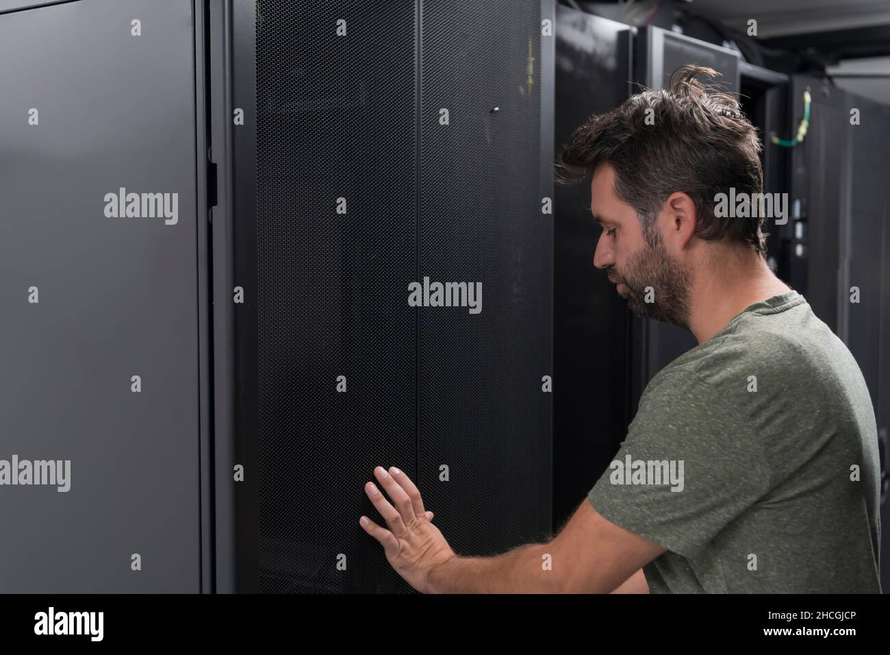 Technicians team updating hardware inspecting system performance in super computer server room or cryptocurrency mining farm. Stock Photo